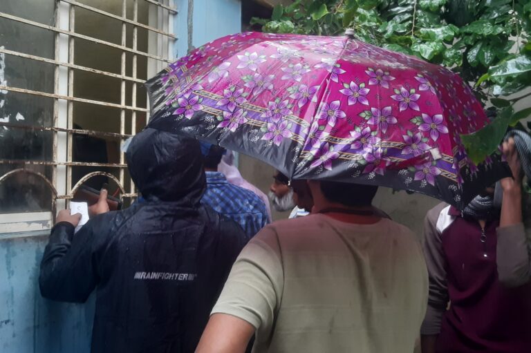 बारिश के बरसते पानी में भीग कर बिजली बिल जमा करने को मजबूर उपभोक्ता